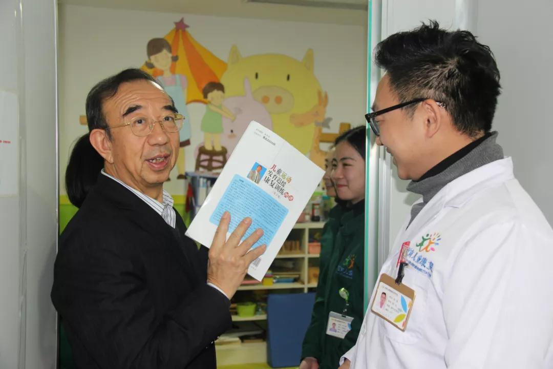 刘振寰教授手握《儿童运动发育迟缓康复训练》书籍