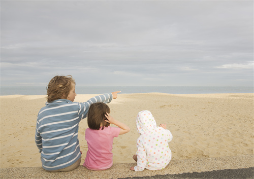 孩子们坐在沙滩边
